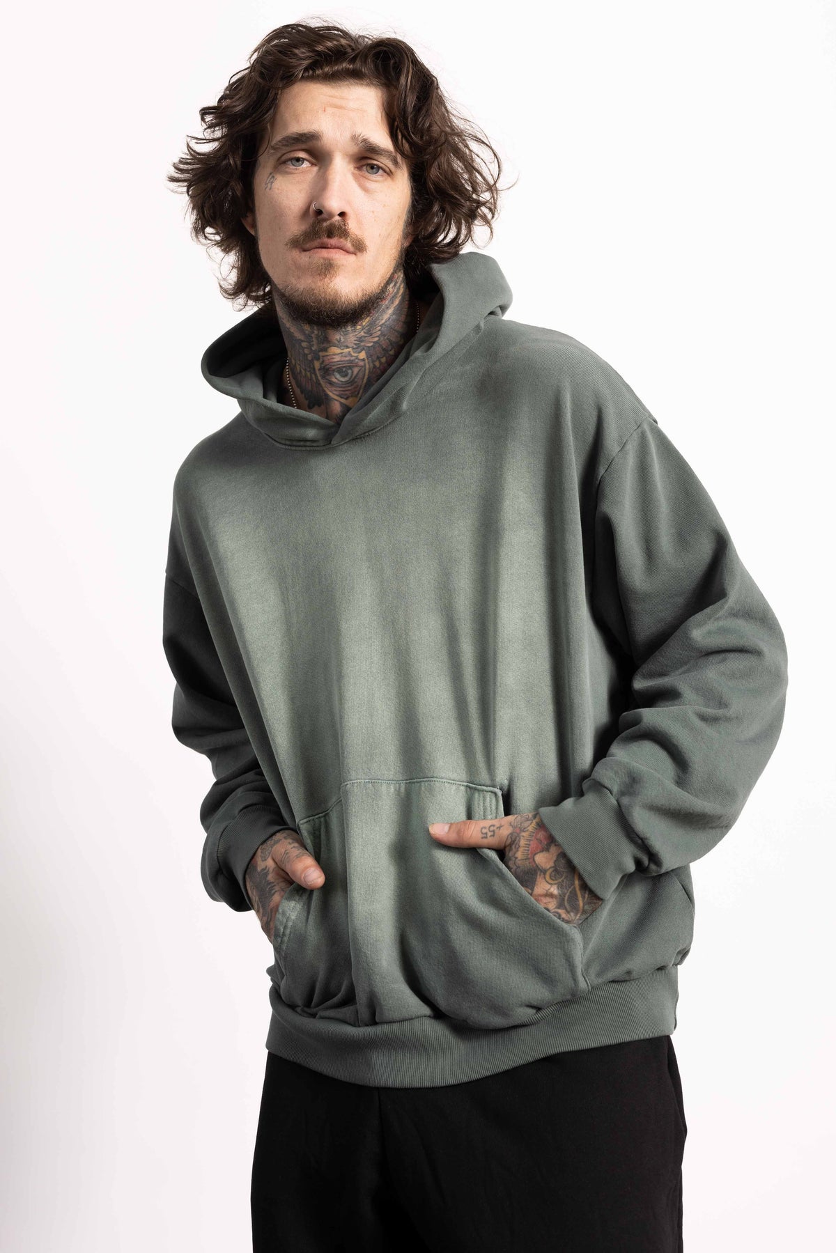 White male model with edgy style wearing a heavyweight cotton vintage green hoodie