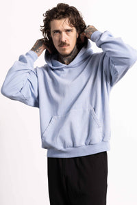 White male model with edgy style wearing a heavyweight cotton light blue hoodie