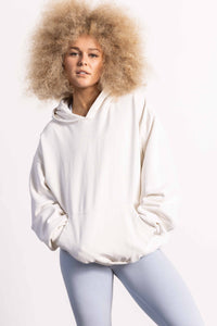 White female model with edgy style and big afro hair style wearing a heavyweight cotton off white hoodie