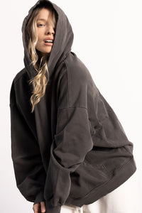 White female blonde model with edgy style wearing a drop shoulder pima cotton hoodie