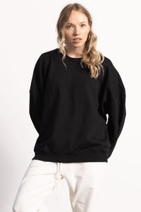 White female model with edgy style wearing a heavyweight  black Pima Cotton Crewneck Sweatshirt.