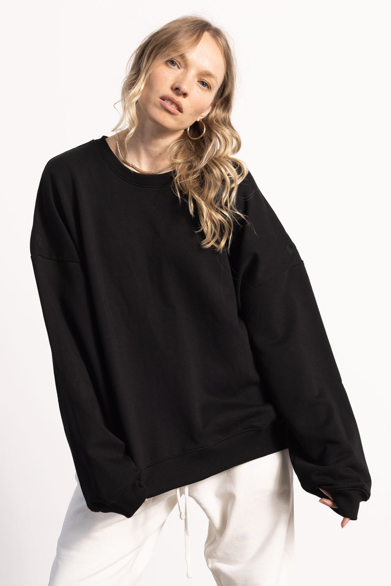 White female model with edgy style wearing a heavyweight  black Pima Cotton Crewneck Sweatshirt.