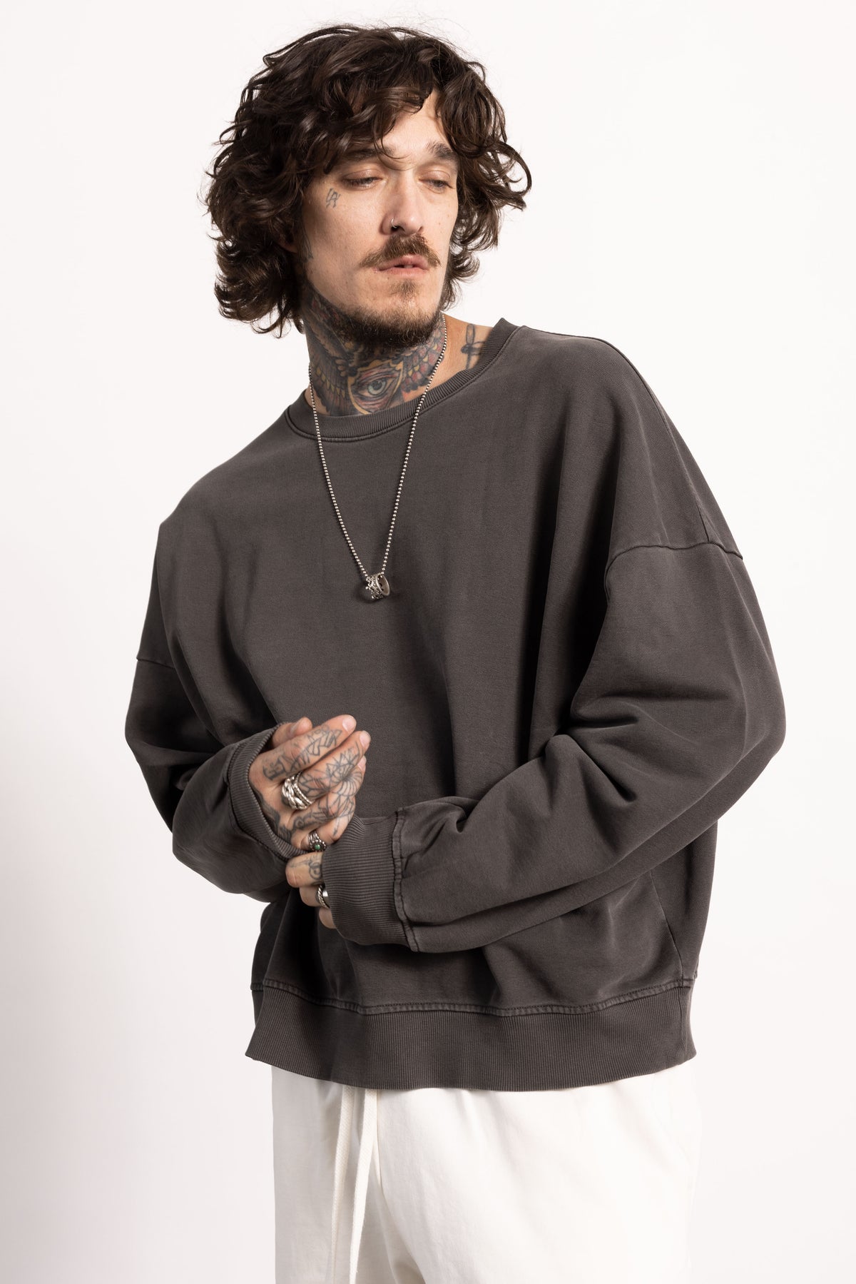 male white edgy model with tattoos wearing an oversized sweatshirt